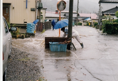 大雨による洪水で物が流れないように細工する町民