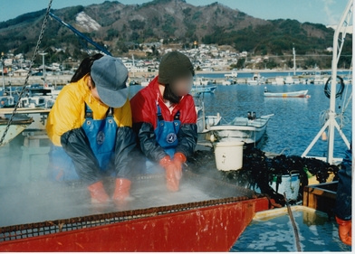 寒い中海岸でワカメのボイル作業をする女性たち