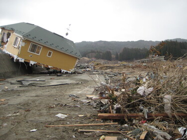堤防に寄りかかる被災家屋